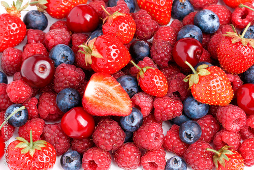 Fototapeta Naklejka Na Ścianę i Meble -  Strawberries, raspberries, blueberries, cherries on a white isolated background. Lots of fresh berries. Healthy food. Mountain of berries. Large berries top view