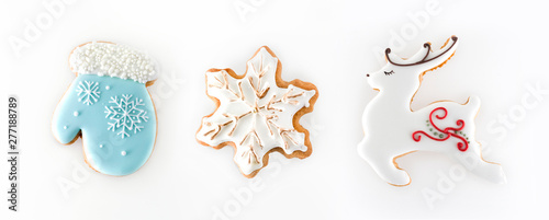 Christmas gingerbread isolated on white background. Set ginger biscuit cookies in shape of a blue mitten, snowflake and a white reindeer.