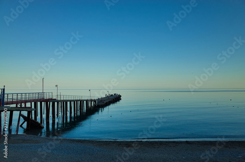 Evening in Sudak  the Republic of Crimea. Fishermen on the pier. Black Sea Coast