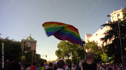 A spectator waves a gay rainbow flag at an LGBT summer gay pride parade photo