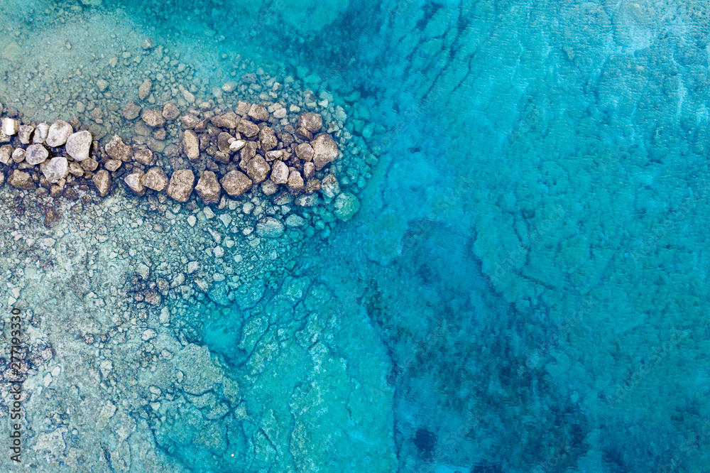 An aerial view of the beautiful Mediterranean sea, where you can se the rocky textured underwater corals and the clean turquoise water of Protaras, Cyprus