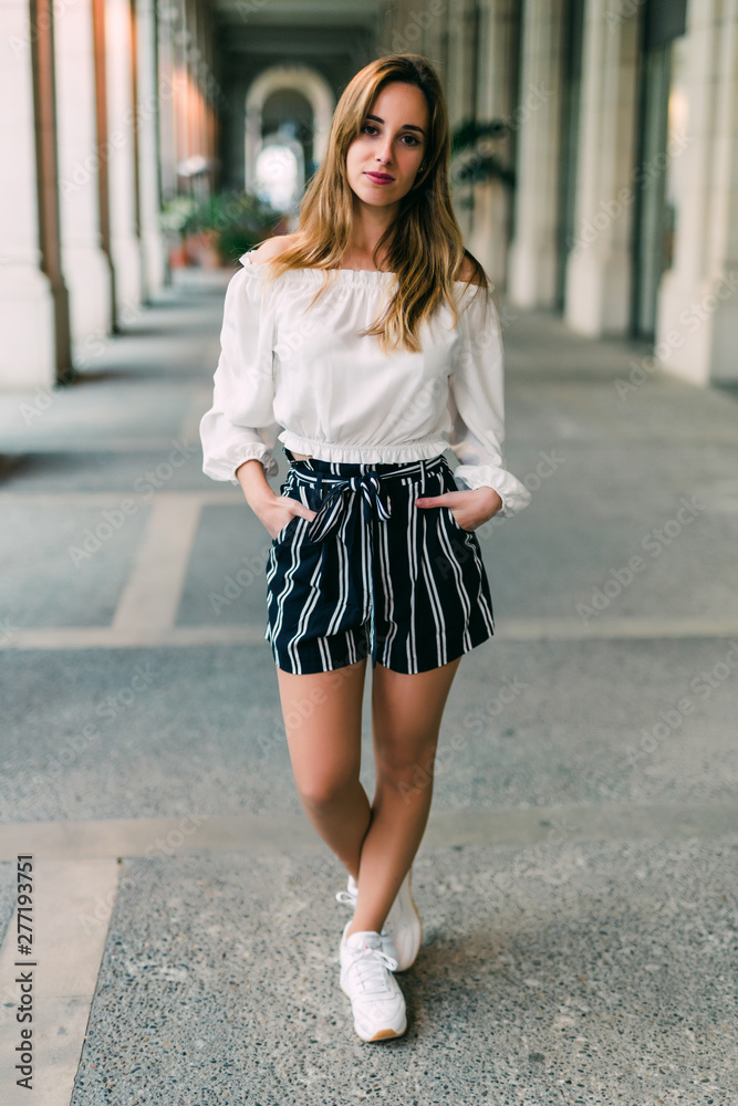 Portrait of young happy smiling beautiful elegant woman in black dress walking at city streets. Portrait of young happy smiling beautiful elegant woman in black dress walking at city streets.