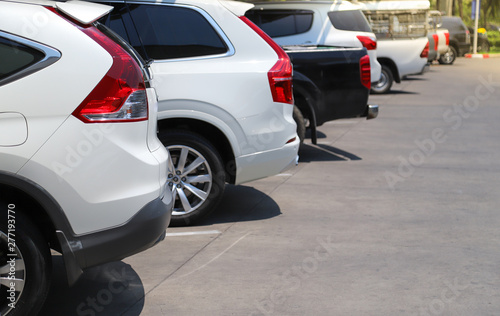 Closeup of rear, back side of white car with  other cars parking in outdoor parking lot. © Amphon