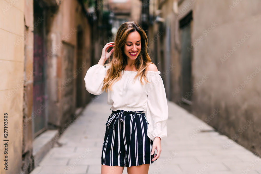 Fashionable girl laughing to camera while resting in summer day. Young caucasian female model enjoying vacation. Fashionable girl laughing to camera while resting in summer day. Young caucasian female model enjoying vacation.