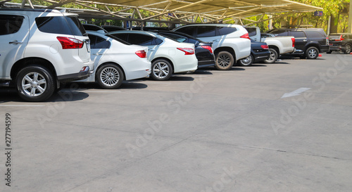 Closeup of rear, back side of white car with  other cars parking in parking lot under roof in bright sunny day.  © Amphon