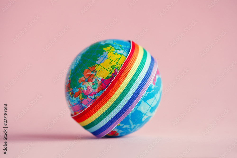 globe with LGBT colorful rainbow ribbon on pink background globe with LGBT colorful rainbow ribbon on pink background