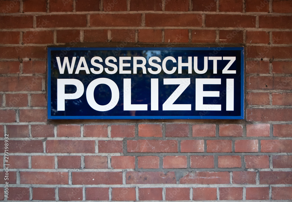 Fototapeta premium Düsseldorf 2019: Sign from the river Police at media harbour Dusseldorf in front of red brick wall. The sign says 