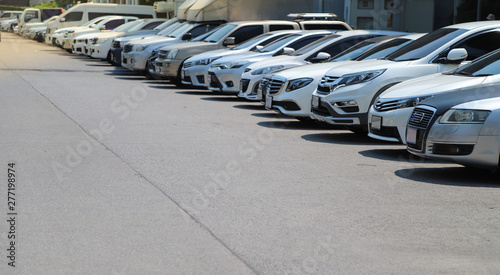 Closeup of front side of  cars parking in outdoor parking lot beside the street in bright sunny day. 