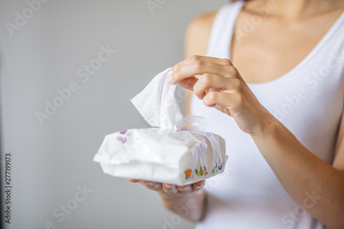 Wet wipes: woman take one wipe from package for cleaning photo