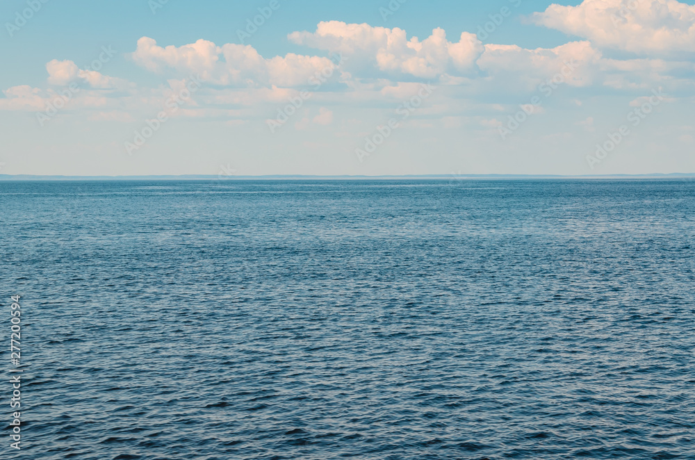 Calm sea against blue sky with clouds. Harmony of sea elements. Seascape. Copy space