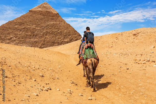 Tourists riding camels near the Pyramid of Khafre, Giza