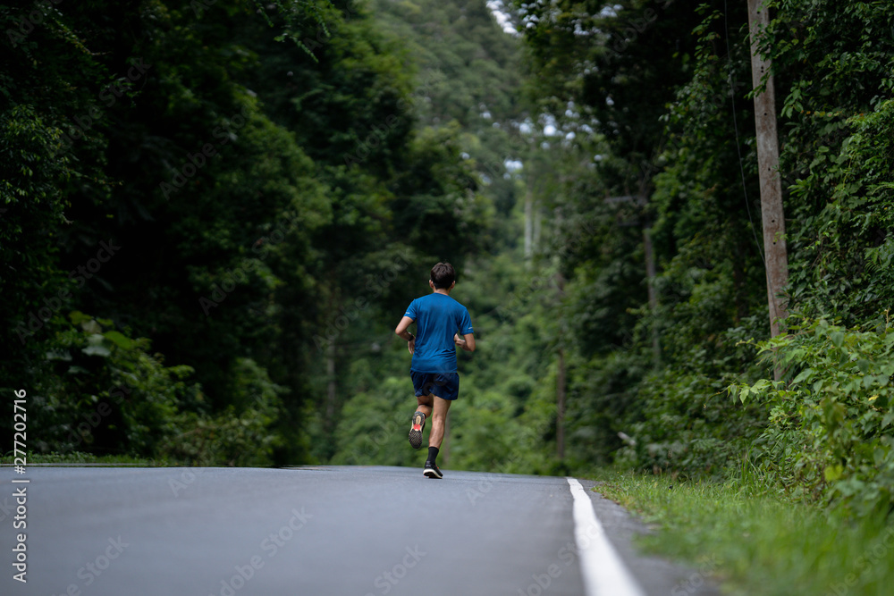 Asian man are running training in roads with forests. Asian man are running training in roads with forests.