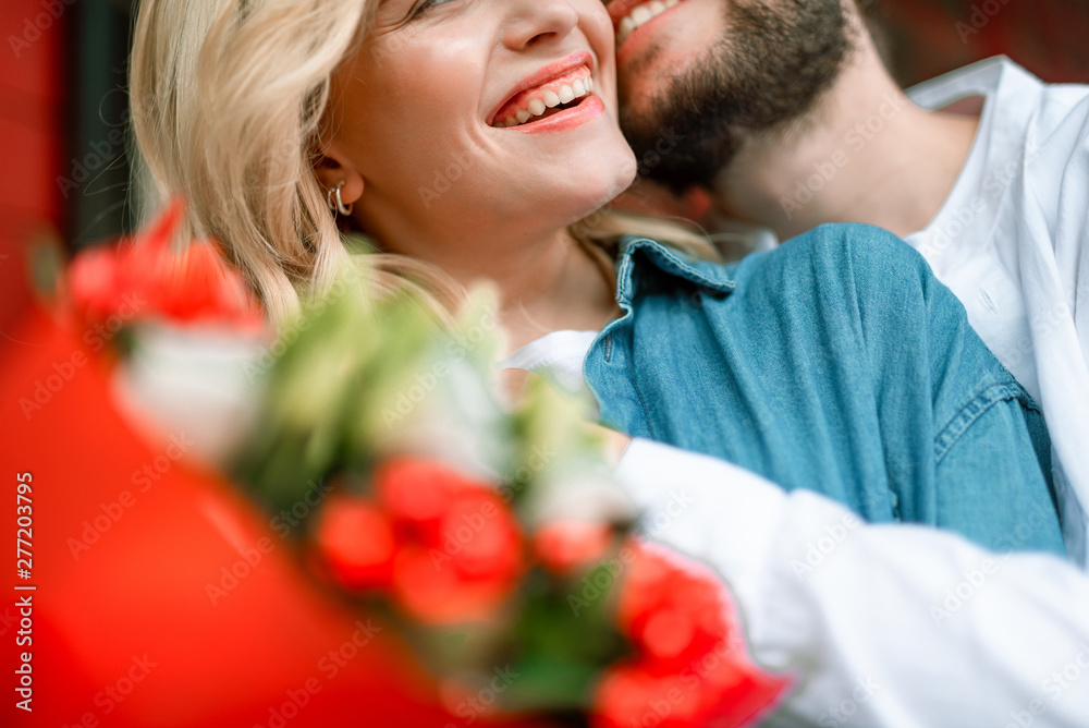 Pretty woman enjoying of flowers from man