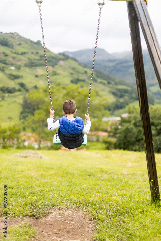 Swinging child on the middle of a field Swinging child on the middle of a field
