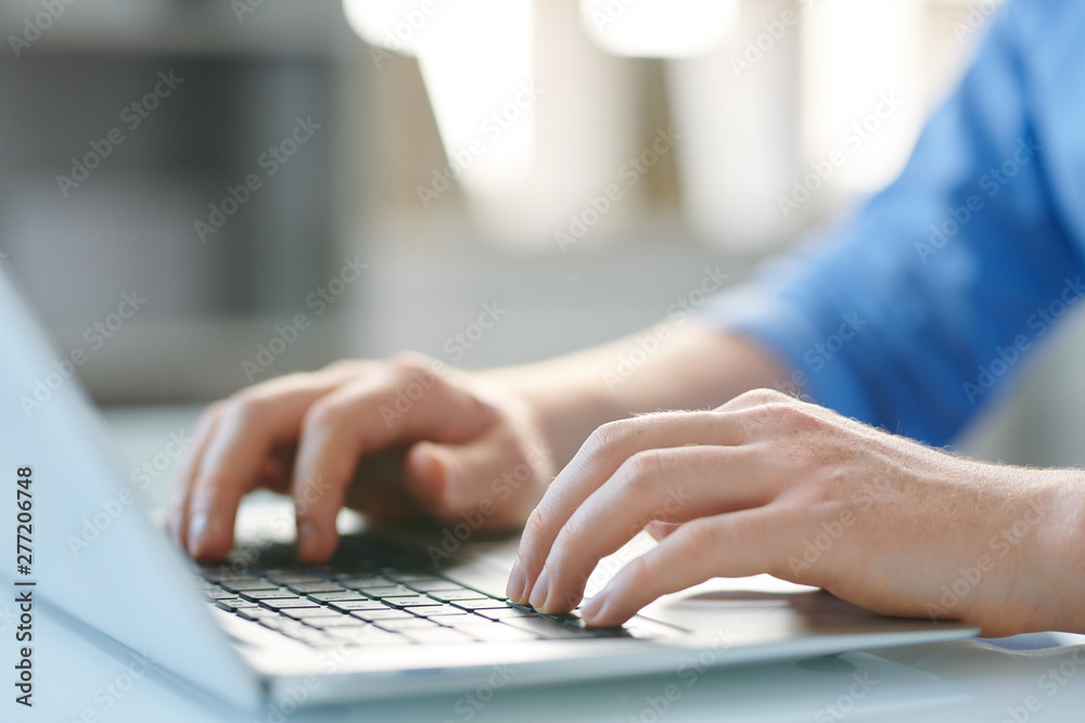 Hands of young mobile male employee pressing keys of laptop keypad ...