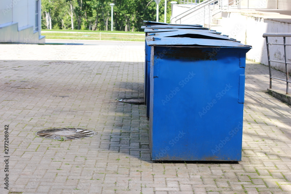 Metal garbage containers are arranged in a row. Metal garbage containers are arranged in a row.