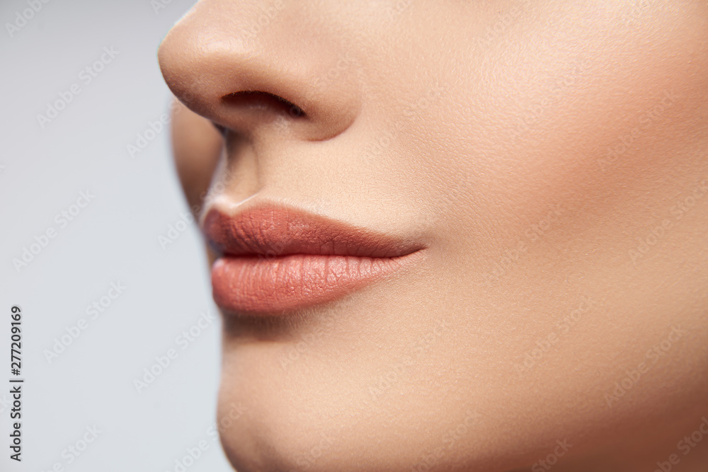 Calm lady posing on light gray background in studio