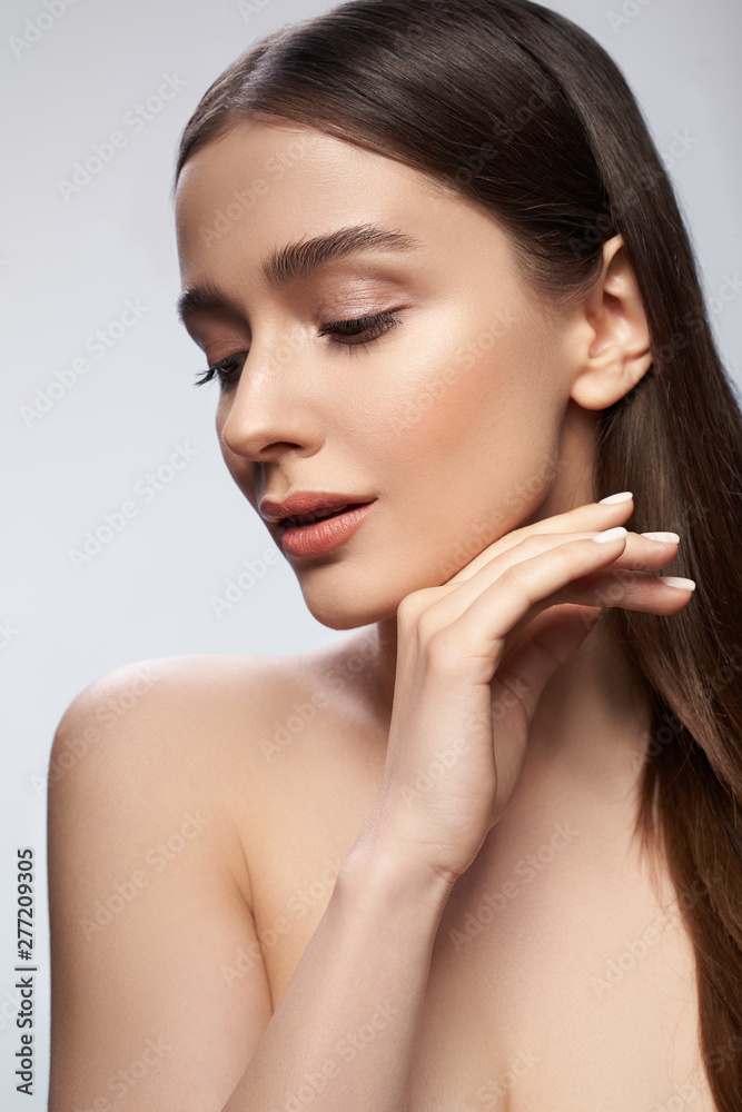 Pretty young woman is posing against light gray background Pretty young woman is posing against light gray background