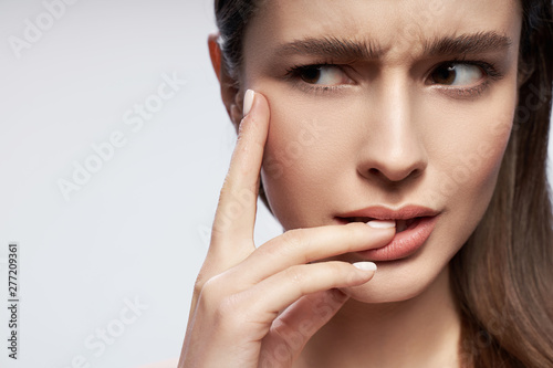 Young lady with natural makeup touching her lips
