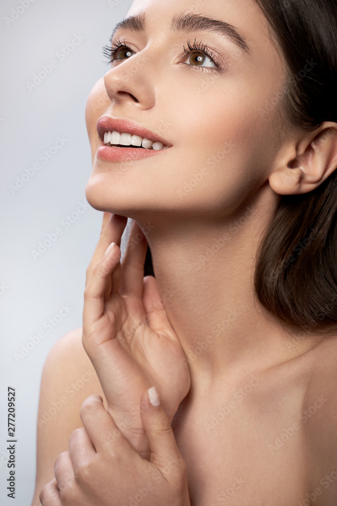 Beautiful young lady with perfect skin keeping hand near face Beautiful young lady with perfect skin keeping hand near face