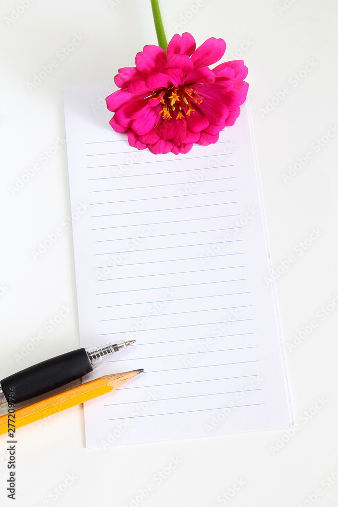 Naklejka premium blank notepad with flower,pencil,pen on a white background top view