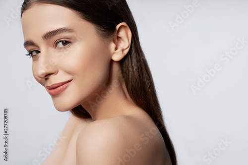 Happy young woman with natural makeup posing in studio