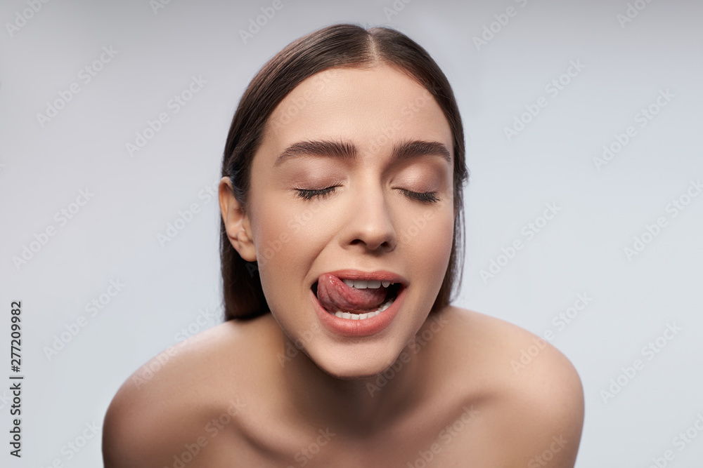 Young female with beautiful brown eyes showing her tongue Young female with beautiful brown eyes showing her tongue