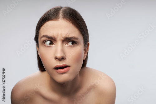 Young lady with beautiful brown eyes raising eyebrows