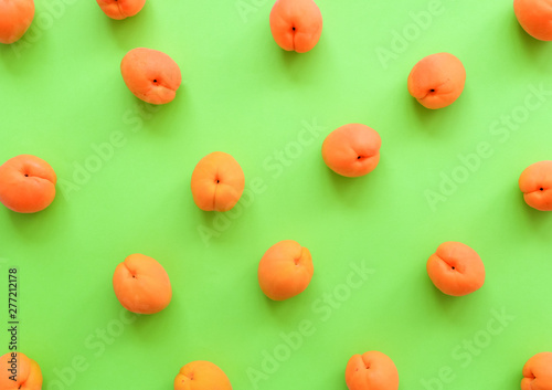 Apricot on bright green background. Apricot pattern. Top view, flat lay
