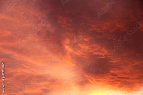 purple red alarming sunset sky with blood orange clouds and bright sunshine like fire