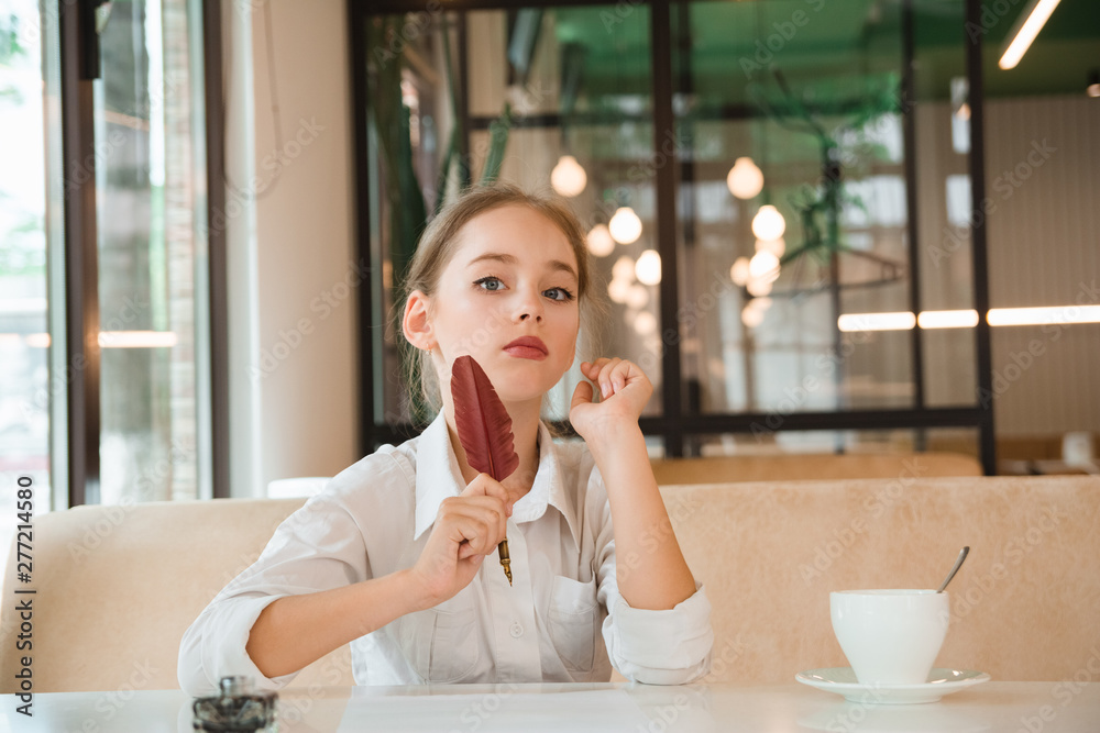 Girl meditates over cup of tea. Business child in tie and shirt Girl meditates over cup of tea. Business child in tie and shirt