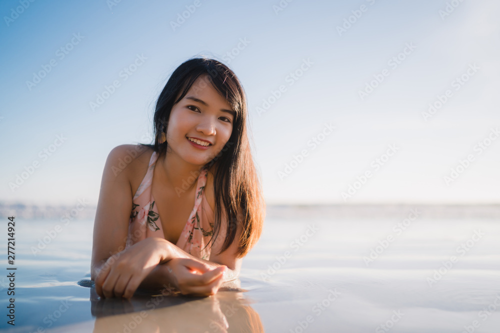 Young Asian woman feeling happy on beach, beautiful female happy relax smiling fun on beach near sea when sunset in evening. Lifestyle women travel on beach concept. Young Asian woman feeling happy on beach, beautiful female happy relax smiling fun on beach near sea when sunset in evening. Lifestyle women travel on beach concept.