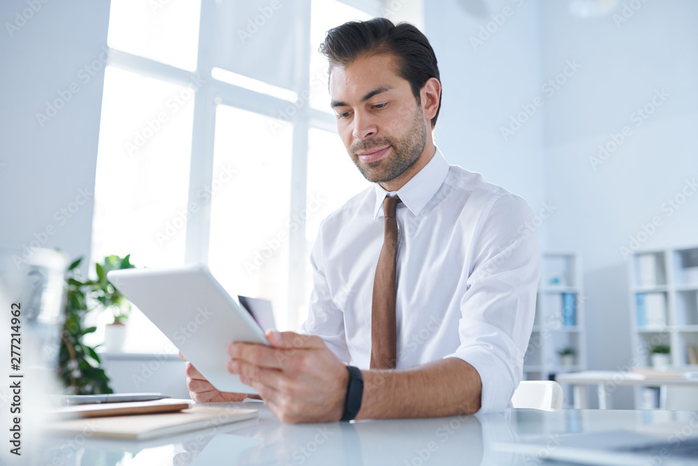Young businessman with tablet analyzing data in the net Young businessman with tablet analyzing data in the net