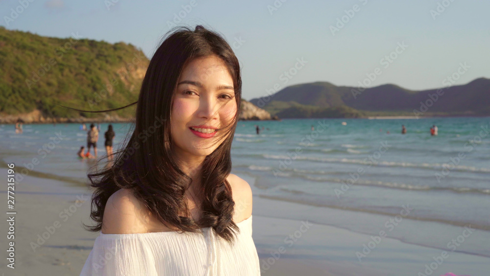 Young Asian woman walking on beach. Beautiful female happy relax walking on beach near sea when sunset in evening. Lifestyle women travel on beach concept. Young Asian woman walking on beach. Beautiful female happy relax walking on beach near sea when sunset in evening. Lifestyle women travel on beach concept.