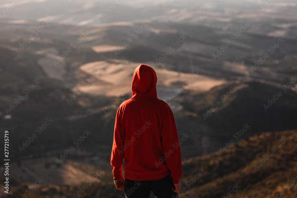 Fototapeta premium Man with red sweatshirt with blurred landscape