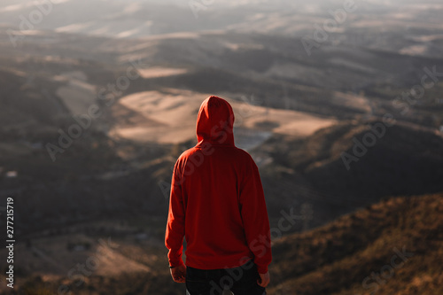 Man with red sweatshirt with blurred landscape