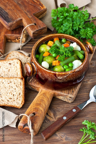 Bowl of vegetable soup with rye bread, selective focus