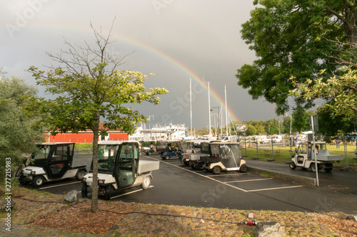 Rainbow strikes on a white house on a cloudy day
