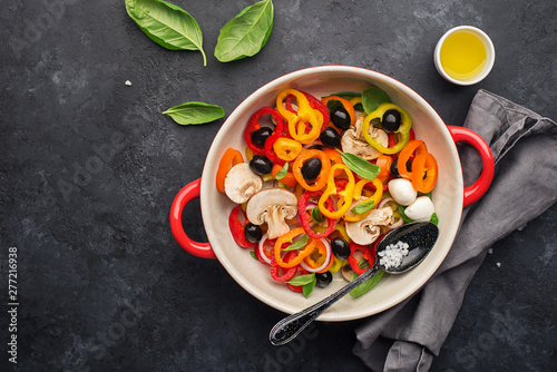 Healthy food. Fresh vegetables, bell peppers capsicum, olives, onions, basil, mozzarella cheese. In a ceramic dish before cooking. Ingredients for frittata, scrambled eggs, grilled vegetables, fresh