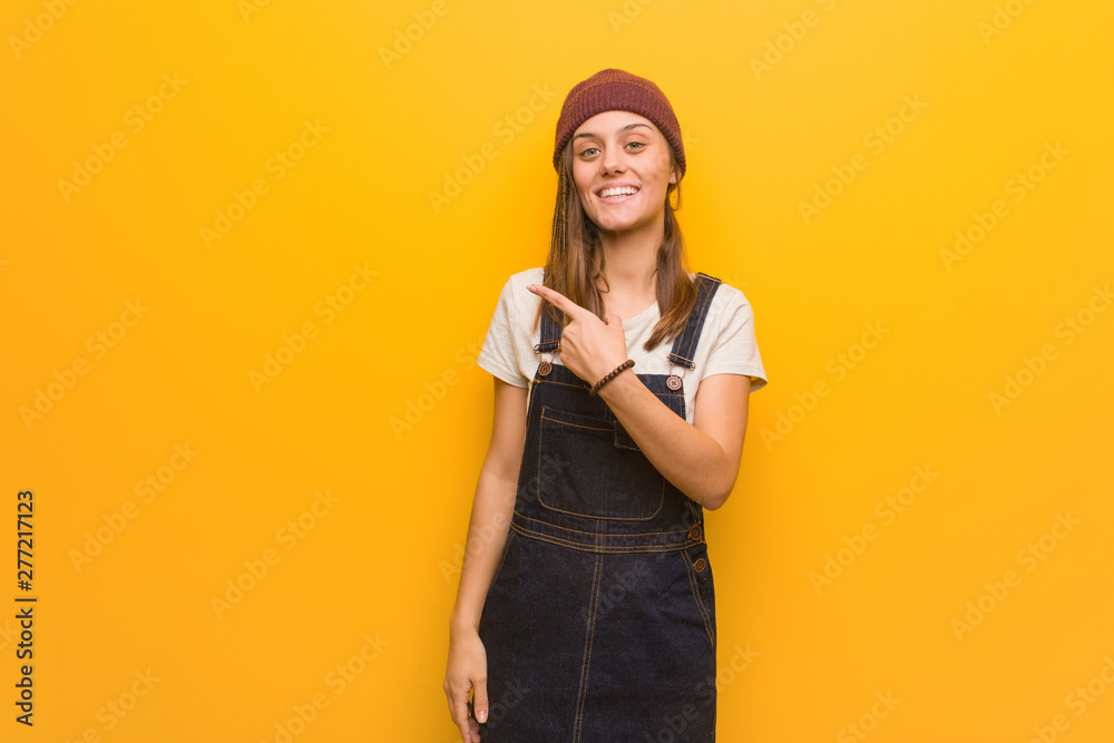 Young hipster woman smiling and pointing to the side Young hipster woman smiling and pointing to the side
