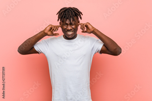 Young african black man covering ears with his hands.