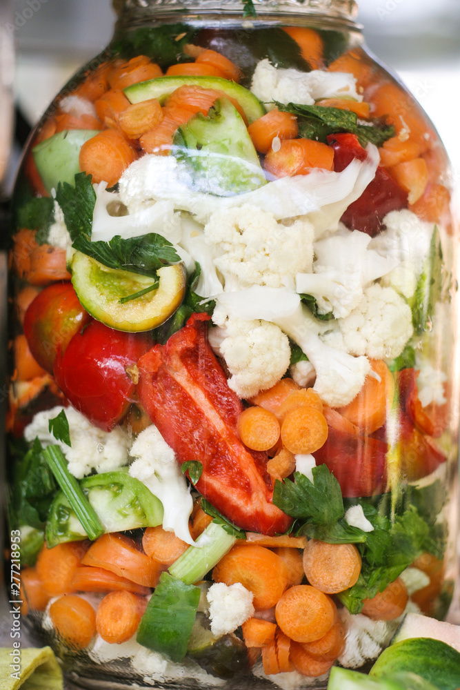 Hand made rural pickled vegetables food for the winter with carrots, peppers, paprika, cauliflower and celery in a big jar. Hand made rural pickled vegetables food for the winter with carrots, peppers, paprika, cauliflower and celery in a big jar.