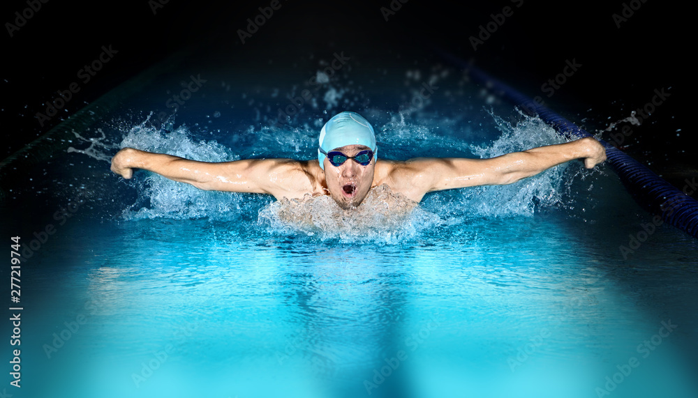 Man in swimming pool. Butterfly style