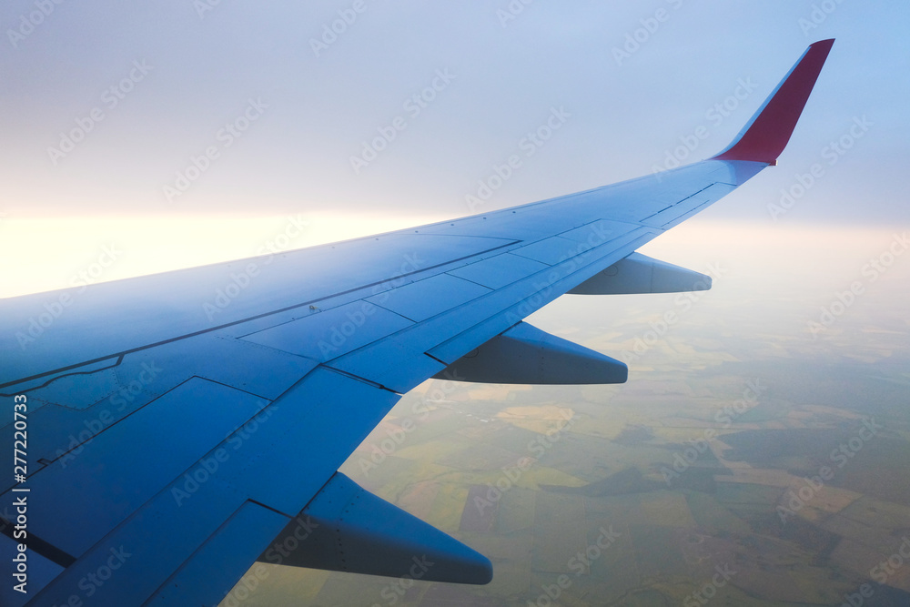 Fototapeta premium View from airplane window with sky and white clouds at the sunset