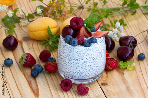 Chia seed pudding with berries on wooden table. rustic stile healthy Breakfast. Chia seed with milk, fruits and fresh berry. well being weight loss concept. yogurt drink, vitamin cocktail.