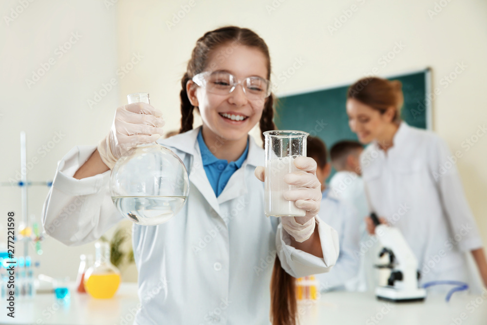 Schoolgirl making experiment in chemistry class, closeup Schoolgirl making experiment in chemistry class, closeup