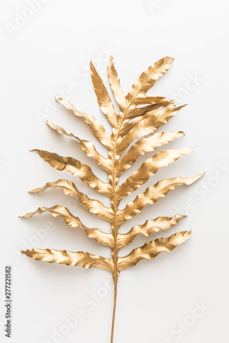 Creative layout with golden tropical leaves on white background. Minimal summ...