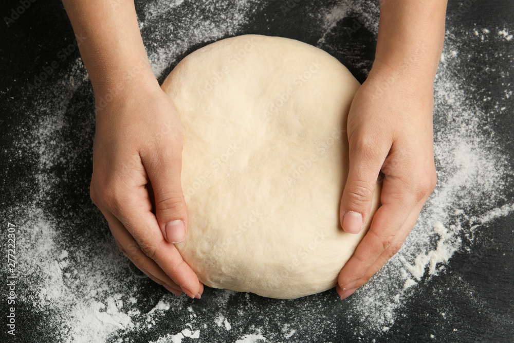Female baker preparing bread dough at grey table, top view Female baker preparing bread dough at grey table, top view