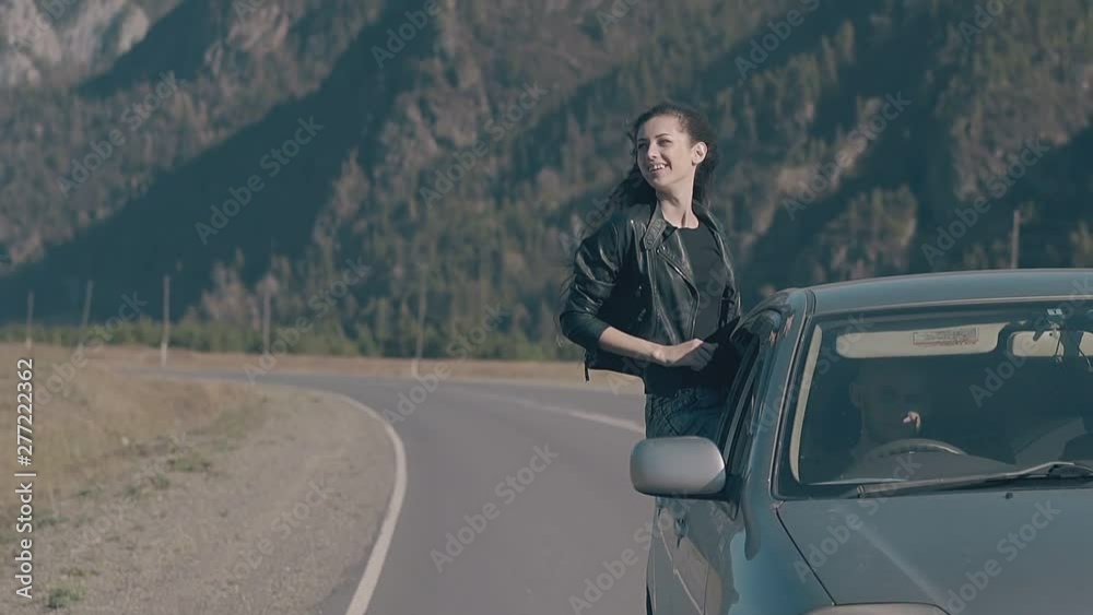 dark haired woman leans out of automobile window and gets pleasure from fantastic car trip close view slow motion dark haired woman leans out of automobile window and gets pleasure from fantastic car trip close view slow motion