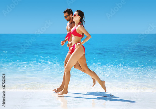 Fit couple doing jogging on a tropical beach